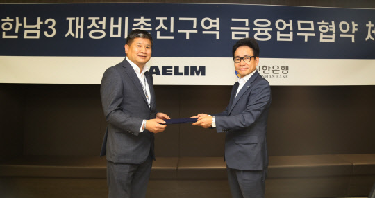 대림산업 이종태 주택영업실장과 신한은행 이영철 본부장이 한남3구역 재개발 사업비 조달을 위한 금융업무협약을 체결하고 협약서를 교환하고 있다. <대림산업 제공>